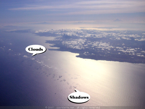 Low-lying clouds casting shadows on the sea, view from plane