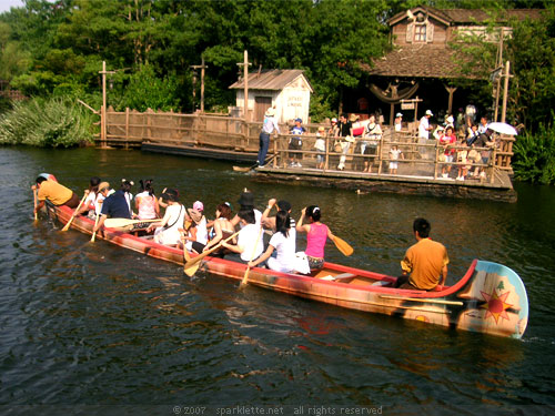 A bunch of Japanese rowing a boat in the hot summer heat, Disneyland