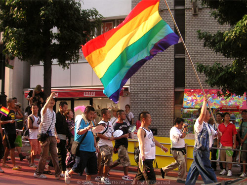 Gay parade with rainbow-coloured gay pride flag