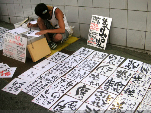 Guy selling calligraphy outside Harajuku Station, Tokyo