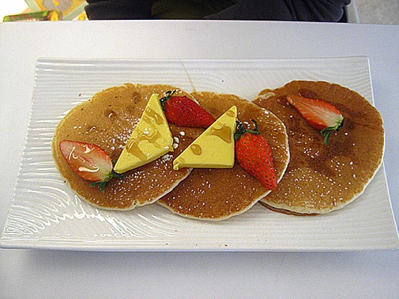 Pancakes with fresh strawberries, maple syrup and butter